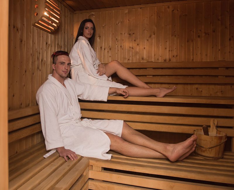 Portrait of a young happy beautiful couple enjoys relaxing in the sauna